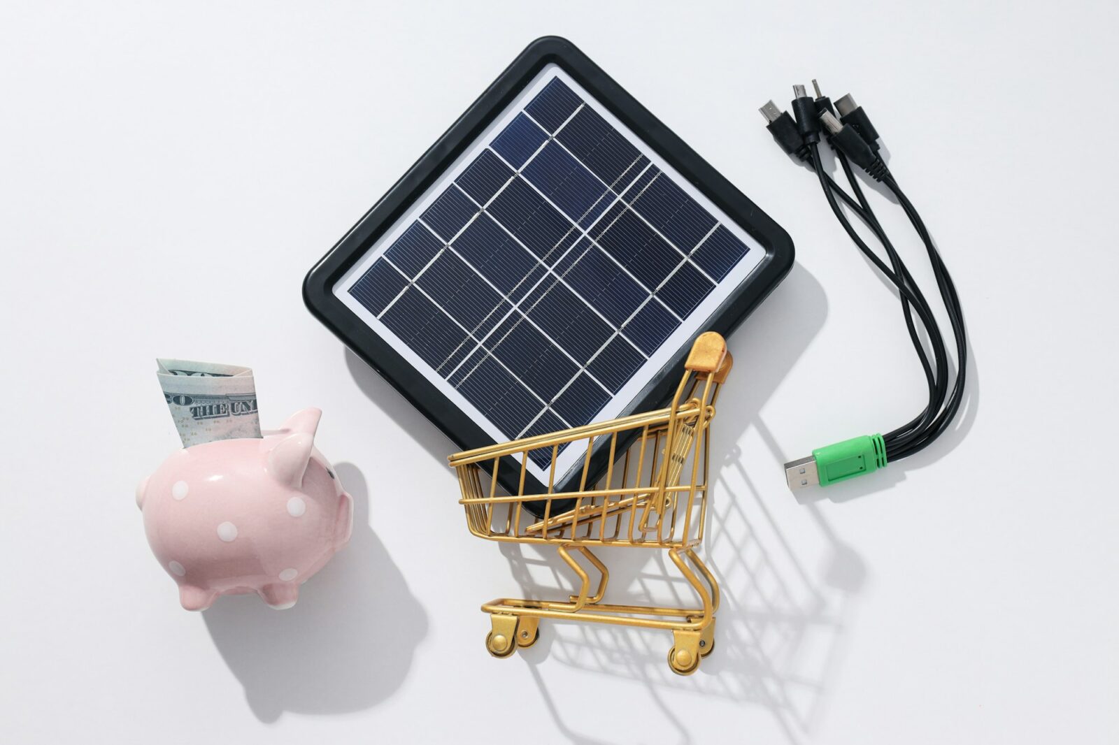 Solar panel, piggy bank and trolley on white background, top view